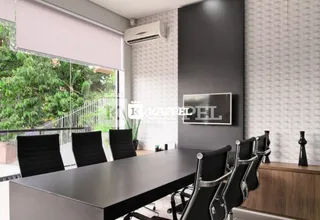 Foto de uma sala de jantar com mesa escura e cadeiras pretas.