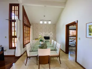 Sala de jantar com mesa de vidro e cadeiras em um imóvel.