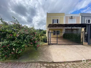 Fachada de uma residência em Lajeado, Brasil com cerca e portão de ferro.