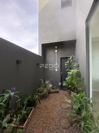 Fachada moderna de uma residência com jardim na frente.