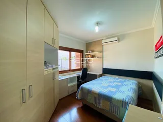 Quarto com armário embutido e piso de madeira.