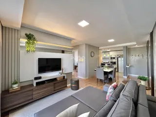 Sala de estar de um apartamento moderno com área de jantar e cozinha integrada.