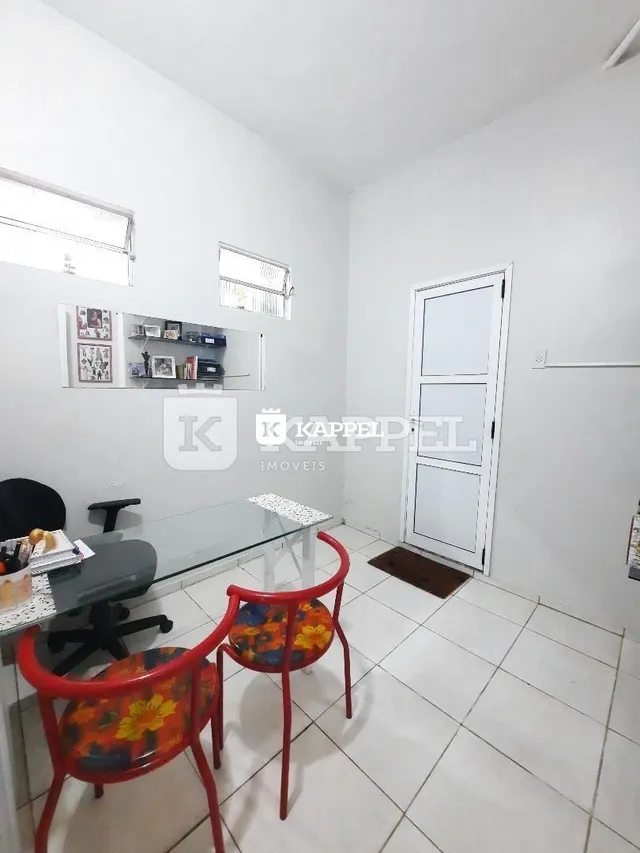 Ambiente interno com mesa e cadeiras em um cômodo claro.