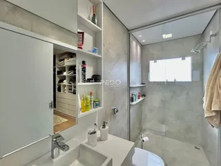 Foto de um banheiro moderno com box de vidro e bancada branca.