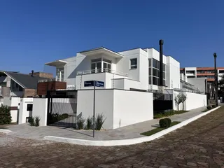 Fachada de uma casa moderna branca com muro e portão em Lajeado, Brasil.