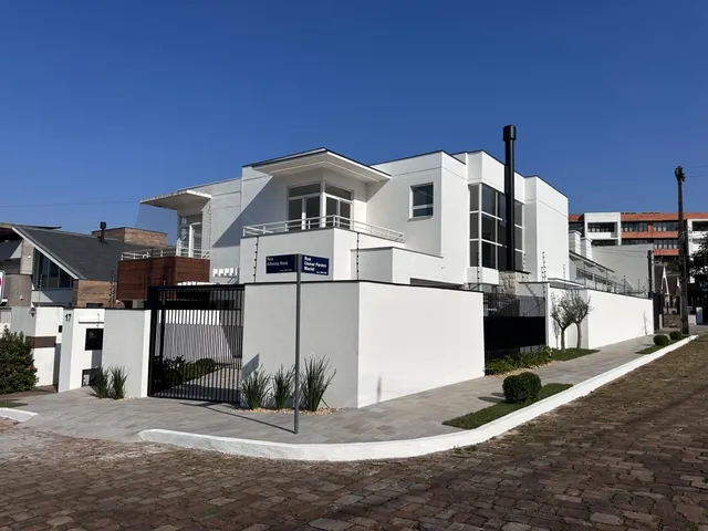 Fachada de uma casa moderna branca com muro e portão em Lajeado, Brasil.