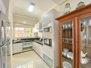 Foto de uma cozinha moderna com armários brancos e eletrodomésticos em aço inoxidável.