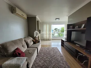 Sala de estar com sofá e televisão em um apartamento.