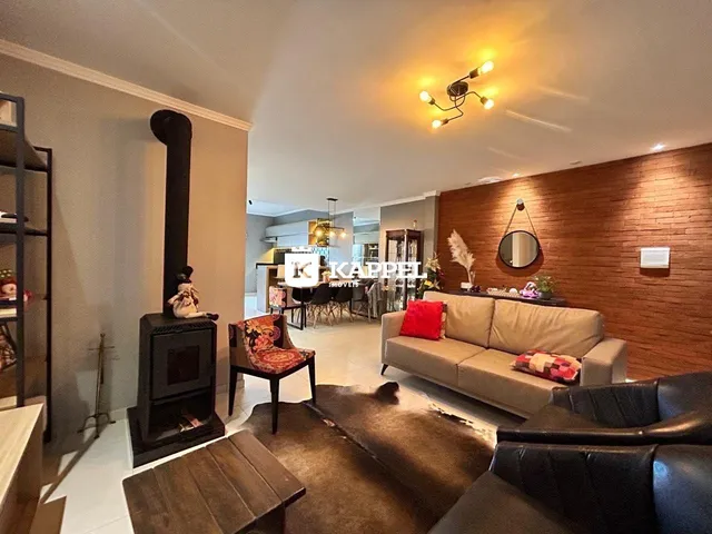 Sala de estar com lareira e sofá de cor neutra.