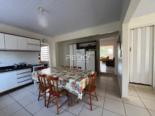 Vista interna de uma sala de jantar com armários brancos e piso cerâmico.
