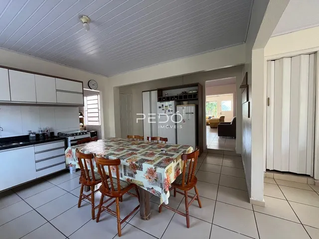 Vista interna de uma sala de jantar com armários brancos e piso cerâmico.