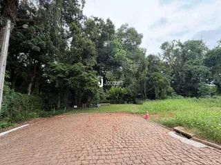 Vista externa de uma área pavimentada com grama e árvores em Lajeado.