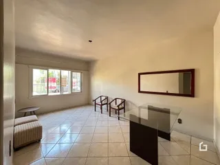 Sala de estar com piso de cerâmica clara e grande janela.