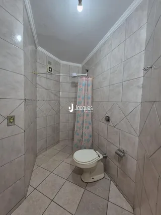 Foto interna de um banheiro com revestimento cerâmico e piso de cerâmica.