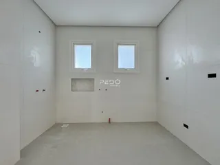 Interior de um cômodo com paredes brancas e piso de concreto.