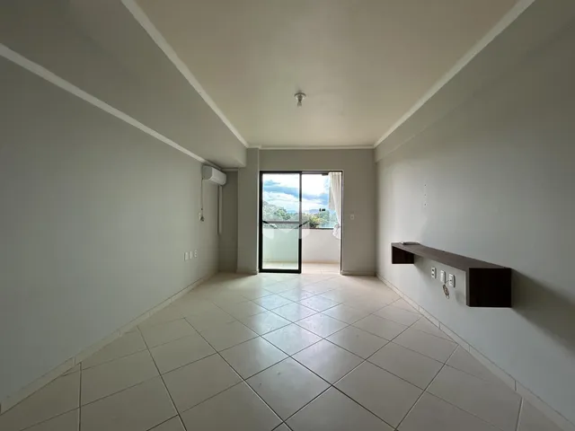 Vista de um corredor interno com piso de cerâmica e porta de vidro.