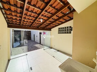 Vista interna de um ambiente com teto de madeira exposta e piso de cerâmica branca.