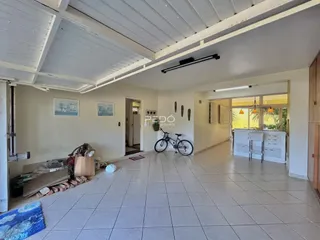 Ambiente interno de uma sala com piso de cerâmica e teto inclinado.