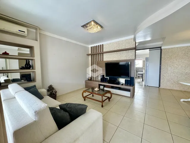 Sala de estar com sofá e televisão em um imóvel no Brasil.