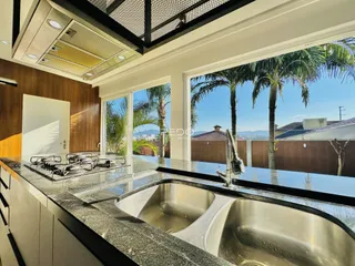 Vista da cozinha com bancada e janela de grande porte em Lajeado.