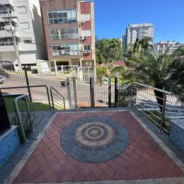 Área externa pavimentada com ladrilhos vermelhos em um imóvel.