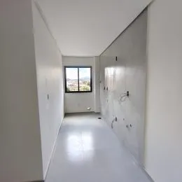 Corredor interno com paredes brancas e piso claro.