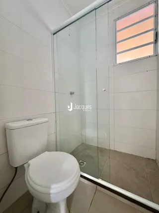 Foto de um banheiro com vaso sanitário e box de vidro.