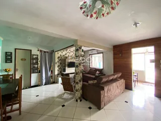 Sala de estar com piso de cerâmica e sofá marrom em um imóvel em Lajeado.