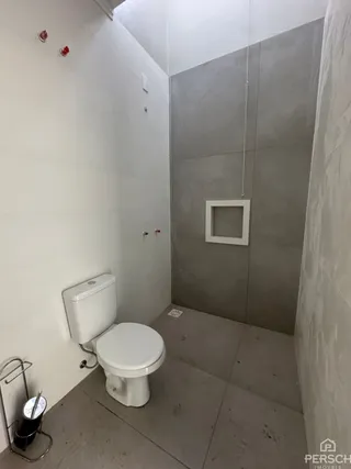 Foto de um banheiro simples com paredes brancas e um vaso sanitário.