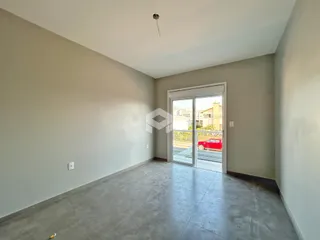 Foto de um ambiente interno com piso de concreto e porta de vidro.
