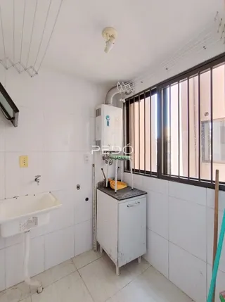 Foto de um banheiro com revestimento branco e piso cerâmico.