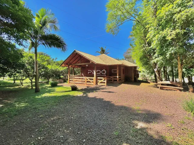 Fachada de uma casa de madeira em uma área arborizada no Brasil.