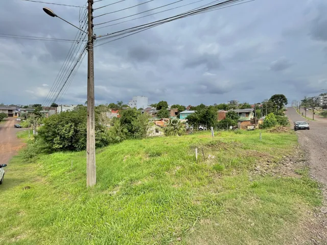 Paisagem de campo com grama e árvores em uma área residencial.