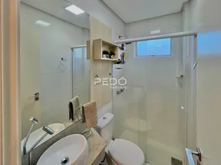 Foto de um banheiro moderno com box de vidro e louças brancas.