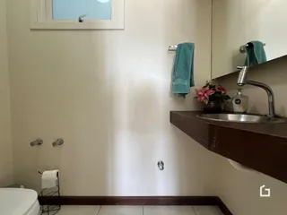 Foto de um banheiro com janela e bancada de madeira.