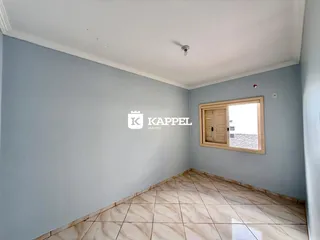 Corredor com piso de cerâmica e parede em tom de azul claro.
