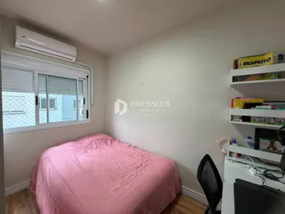 Quarto com cama rosa e janela.