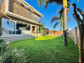 Vista da fachada de uma casa com jardim verde em Lajeado.