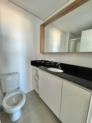 Foto de um banheiro com vaso sanitário e bancada.