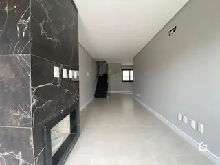 Corredor interno de uma residência com piso claro e paredes cinzas.