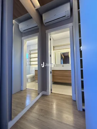 Vista de um corredor interno com portas abertas em um imóvel.