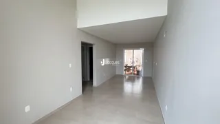 Corredor interno com piso de cerâmica e paredes brancas.
