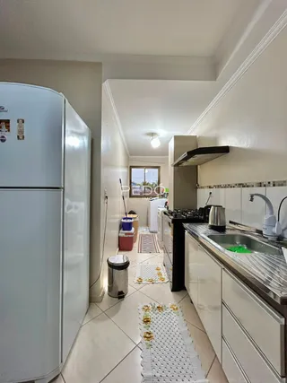Foto da cozinha de uma residência em Lajeado, Brasil, mostrando armários brancos e piso de cerâmica.