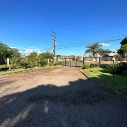Vista da entrada de uma propriedade em Lajeado, Brasil com estrada de terra e vegetação.