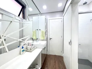 Foto de um banheiro moderno com bancada branca e piso de madeira.