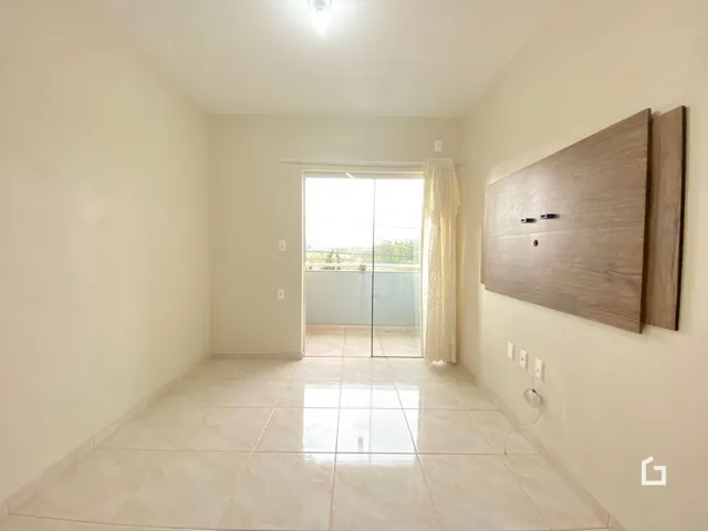 Hall de entrada com piso de cerâmica claro e parede de destaque de madeira.