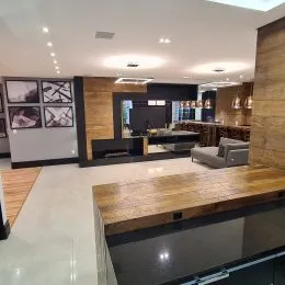 Foto de uma cozinha moderna com armários de madeira e bancadas escuras.