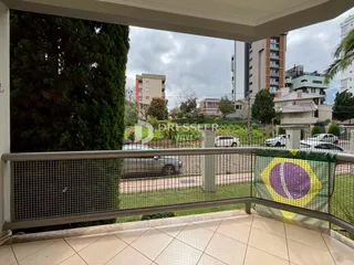 Vista da varanda com grade de proteção e vegetação ao fundo.
