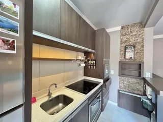 Cozinha moderna com armários de madeira e bancada clara.