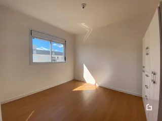 Ambiente interno com piso de madeira e janela em uma residência.